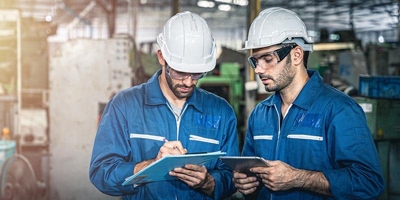 Plant workers updating maintenance logs